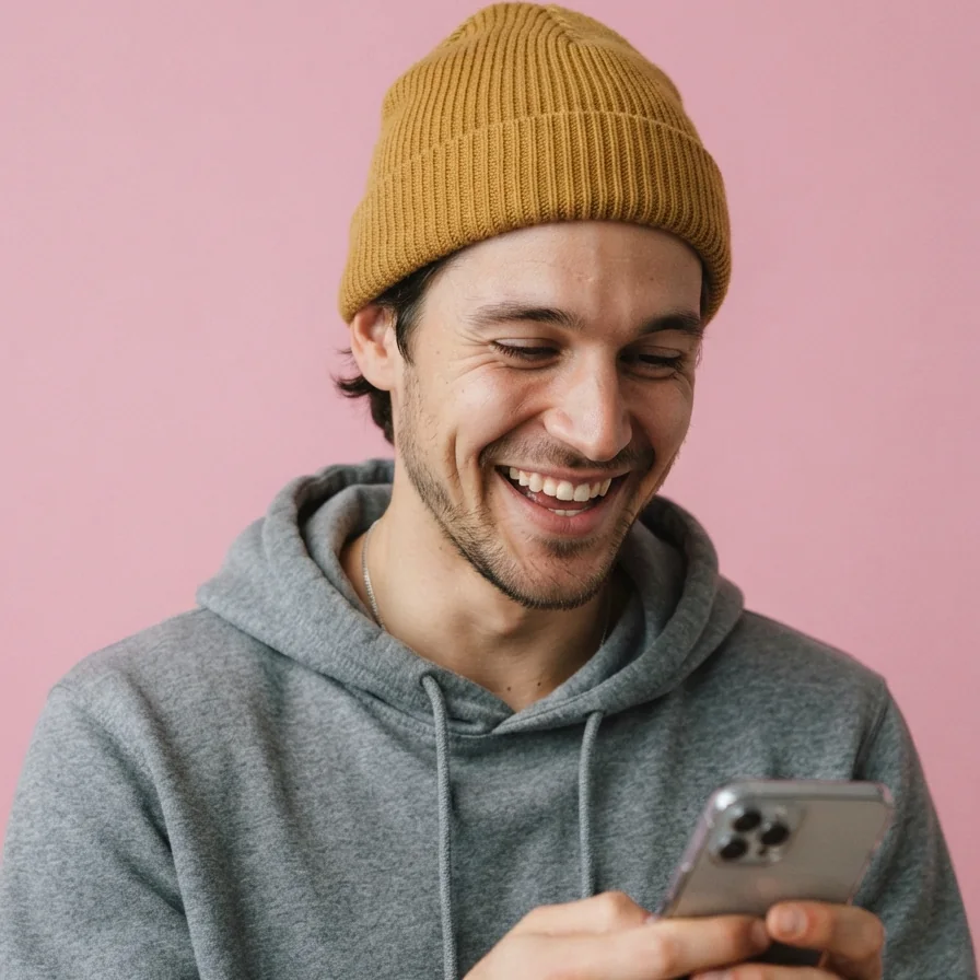 AI-generated model wearing a mustard ribbed knit beanie, laughing at his phone